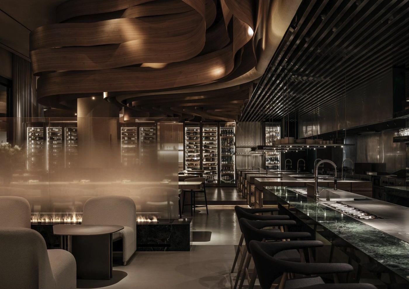 Birch restaurant (Dubai) — 라운지 바. 벽난로 옆 낮은 소파, 테이블을 기다리는 자리