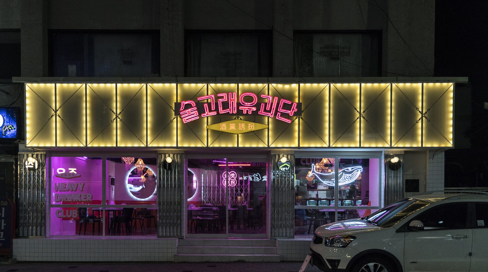 금빛 전구 테두리와 네온 간판이 켜진 밤의 외관